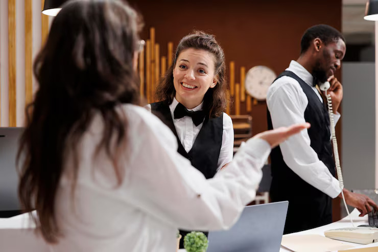 Hotel front desk staff assisting a guest